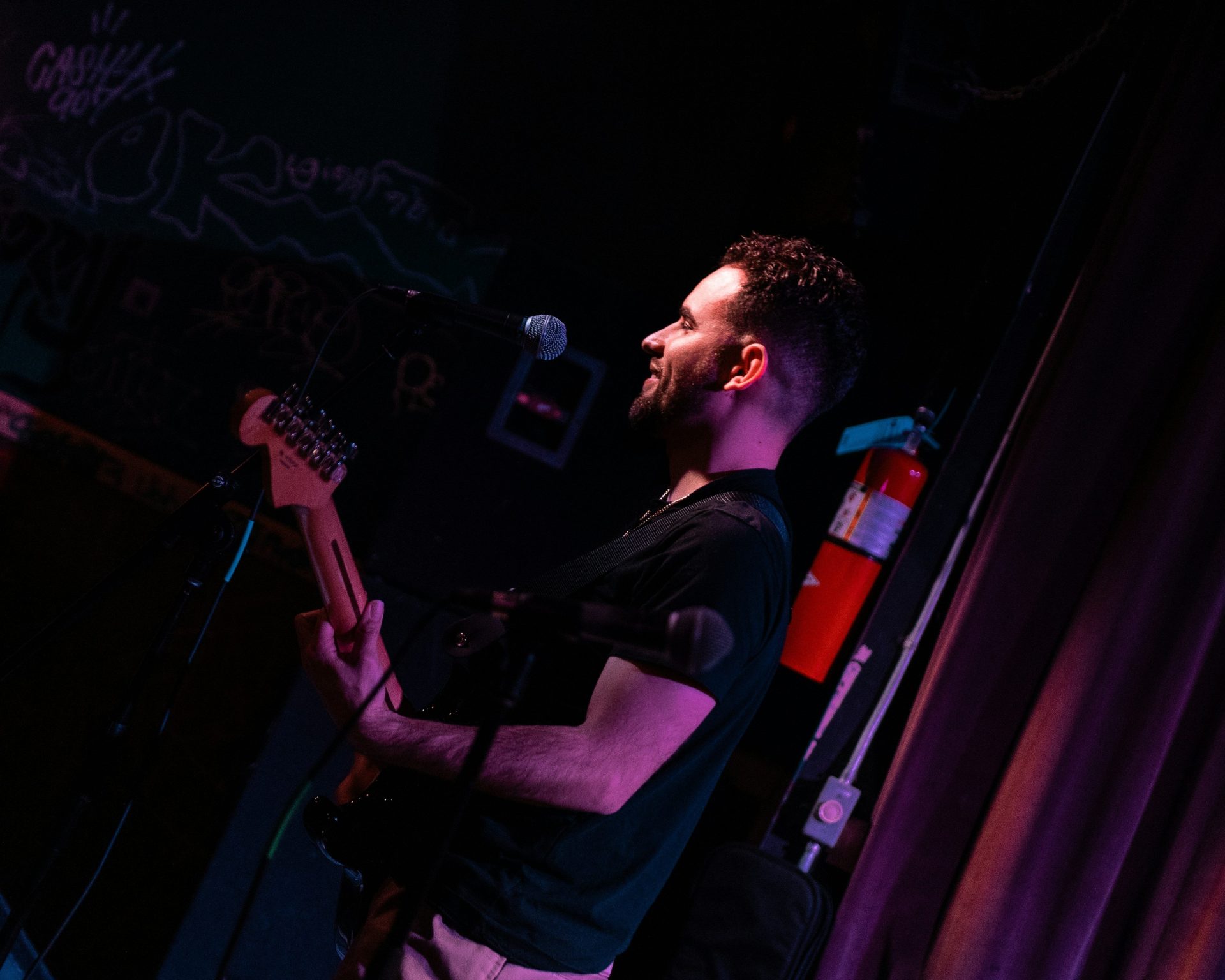 A man standing on a stage with a guitar